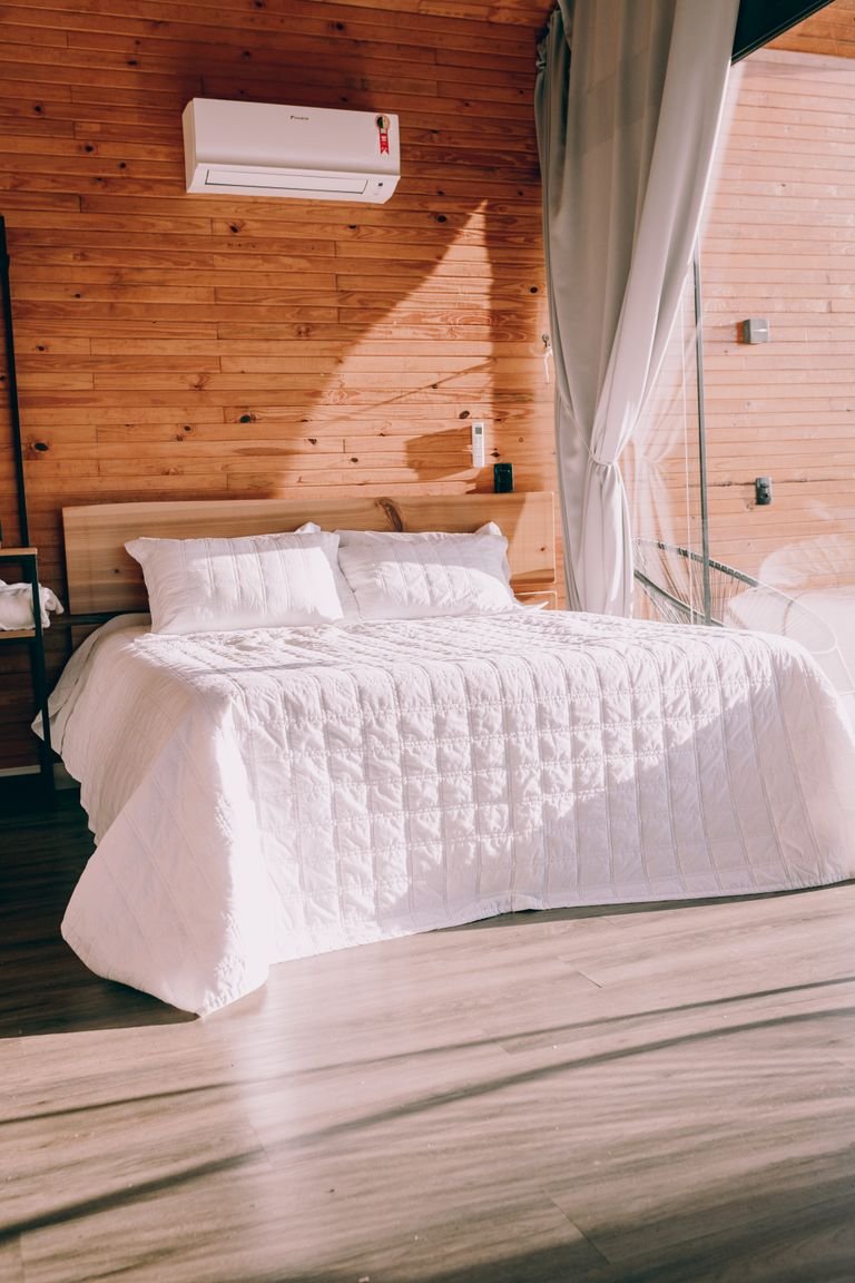 Cama con nórdico blanco en dormitorio cálido