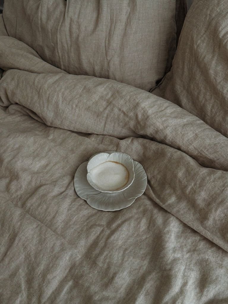 Cama vestida con nórdico y sábanas en tonos neutros